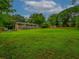 Sprawling backyard with a well-maintained lawn, mature trees, and exterior view of the house at 6892 Autumn Hills Dr, Douglasville, GA 30135