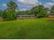 Lush backyard features a well-manicured lawn, mature trees, and partial view of the house exterior at 6892 Autumn Hills Dr, Douglasville, GA 30135