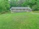 Spacious backyard with green grass, the back of the house, and a patio area for outdoor activities at 6892 Autumn Hills Dr, Douglasville, GA 30135