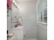 Bright bathroom with a vanity, mirror, modern lighting, and window providing natural light and fresh air at 6892 Autumn Hills Dr, Douglasville, GA 30135