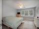 Bright bedroom featuring a large window, wood-look floors, and fresh gray paint with white trim and doors at 6892 Autumn Hills Dr, Douglasville, GA 30135
