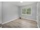 Neat bedroom with light walls, wood-look floors, a window for natural light, and light trim and doors at 6892 Autumn Hills Dr, Douglasville, GA 30135
