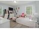 Well-lit bedroom featuring a large window, light-colored wood-look floors, and a bed with a plush comforter at 6892 Autumn Hills Dr, Douglasville, GA 30135