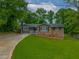 Charming single-story home featuring a brick facade, white trim, and a lush green lawn at 6892 Autumn Hills Dr, Douglasville, GA 30135