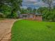 Quaint single-story home with brick and gray siding, a well-maintained lawn, and mature trees at 6892 Autumn Hills Dr, Douglasville, GA 30135