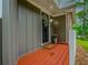 Inviting front porch featuring a wood-look deck, flower pot, wreath on the front door and gray siding at 6892 Autumn Hills Dr, Douglasville, GA 30135