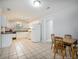Bright kitchen featuring white cabinets, appliances, and adjacent dining area with tile flooring at 6892 Autumn Hills Dr, Douglasville, GA 30135