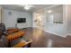 Inviting living room with wood floors, a mounted TV, and an open floor plan leading to the kitchen and dining area at 6892 Autumn Hills Dr, Douglasville, GA 30135