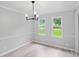 Bright dining room with laminate floors, modern chandelier, and large windows at 805 Wayside Dr, Lawrenceville, GA 30046