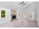 Bright living room with stone fireplace, gray laminate floors, and a ceiling fan at 805 Wayside Dr, Lawrenceville, GA 30046
