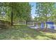 A spacious backyard with a wooded perimeter, concrete patio, and a home with a screened-in porch at 1030 Brockdell Ct, Norcross, GA 30093