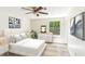 Bright bedroom featuring a ceiling fan, a bed with white linens, modern decor, and a large window overlooking the backyard at 1030 Brockdell Ct, Norcross, GA 30093