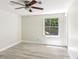 Bedroom features gray laminate flooring, white walls, a ceiling fan and a large window overlooking the yard at 1030 Brockdell Ct, Norcross, GA 30093