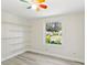 Bedroom featuring a colorful ceiling fan, large window, and a shelving unit for storage and organization at 1030 Brockdell Ct, Norcross, GA 30093