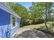 Exterior side view of a home with blue siding, lush greenery, and a driveway at 1030 Brockdell Ct, Norcross, GA 30093