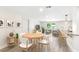 Staged open floor plan with white walls, gray laminate floors, kitchen, and dining and living room furniture at 1030 Brockdell Ct, Norcross, GA 30093