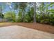 Landscaped backyard featuring a stone patio and lush greenery with mature trees at 1250 Parkview Nw Ln, Kennesaw, GA 30152