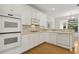 Bright kitchen featuring modern white cabinets, appliances, and hardwood floors at 1250 Parkview Nw Ln, Kennesaw, GA 30152