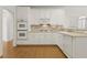 Modern kitchen features white cabinetry, appliances and hardwood flooring at 1250 Parkview Nw Ln, Kennesaw, GA 30152