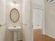 A traditional powder room features a pedestal sink, gold mirror, and neutral wall color at 1250 Parkview Nw Ln, Kennesaw, GA 30152