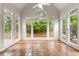 Bright sunroom featuring tile floors and expansive windows overlooking a lush, private backyard at 1250 Parkview Nw Ln, Kennesaw, GA 30152