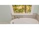 Modern bathroom featuring a soaking tub and a window with backyard views at 1508 Walker Ridge Sw Dr, Marietta, GA 30064
