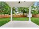 A serene view of the backyard from the covered back porch with lawn and a wooden fence at 1701 Aircraft S Dr, Marietta, GA 30060