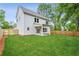 Large grassy backyard with a wooden fence surrounding a two-story home with white siding and a covered porch at 1701 Aircraft S Dr, Marietta, GA 30060