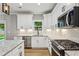 Well-equipped kitchen with stainless steel appliances, granite countertops, stylish backsplash and bright white cabinetry at 1701 Aircraft S Dr, Marietta, GA 30060