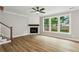 Inviting living room with a modern fireplace, ceiling fan, and large windows offering backyard views at 1701 Aircraft S Dr, Marietta, GA 30060