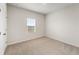 This bedroom has a window and neutral carpet, with fresh white walls at 321 Arwen Dr, Mcdonough, GA 30252