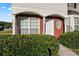 Inviting townhome entrance with a charming round window and well-kept shrubbery at 6099 Camden Forrest Cv, Riverdale, GA 30296