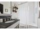Modern bathroom featuring a dark vanity, elegant fixtures, and a shower-tub at 132 Mount Vernon Dr, Decatur, GA 30030