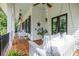 Spacious covered porch featuring hanging swing, ceiling fans, wood floors, and white columns at 132 Mount Vernon Dr, Decatur, GA 30030