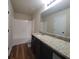 Bathroom featuring granite counters, dark wood cabinets, hardwood floor, and a shower-tub combo at 1474 Union Station, Lawrenceville, GA 30045