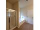 Bright bathroom featuring a glass-enclosed shower, a soaking tub, and tile flooring at 1474 Union Station, Lawrenceville, GA 30045