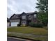 Inviting two-story home with a well-manicured lawn and a two-car garage, complemented by mature landscaping at 1474 Union Station, Lawrenceville, GA 30045