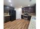 Modern kitchen featuring stainless steel appliances, granite countertops, dark cabinetry, and hardwood flooring at 1474 Union Station, Lawrenceville, GA 30045