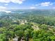 Expansive aerial view showcasing a lush, green neighborhood near a serene lake under a bright, partly cloudy sky at 1620 Bluewater Ct, Cumming, GA 30041