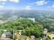 Aerial view of lake property featuring homes nestled among mature trees at 1620 Bluewater Ct, Cumming, GA 30041