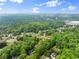 Beautiful aerial view of a tree-lined neighborhood showcasing a picturesque landscape under a partly cloudy sky at 1620 Bluewater Ct, Cumming, GA 30041