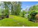 Spacious backyard with mature trees, greenery, and a stone path at 1620 Bluewater Ct, Cumming, GA 30041