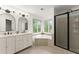 Bright bathroom featuring a double vanity, soaking tub with a view and a stand up shower at 1620 Bluewater Ct, Cumming, GA 30041