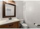 Powder room featuring a wood vanity, round mirror with a decorative frame, and a toilet at 1620 Bluewater Ct, Cumming, GA 30041