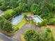 Aerial view of community amenities featuring a tennis court, swimming pool, and playground surrounded by trees at 1620 Bluewater Ct, Cumming, GA 30041