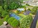 Aerial view showcasing community amenities: tennis court, pool, playground, and parking area, nestled among mature trees at 1620 Bluewater Ct, Cumming, GA 30041