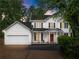 Charming two-story home with white siding, black shutters, red front door, and a well-manicured lawn at 1620 Bluewater Ct, Cumming, GA 30041