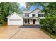 Charming two-story home with white siding, black shutters, red front door, and a well-manicured lawn at 1620 Bluewater Ct, Cumming, GA 30041