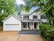 Charming two-story home with white siding, black shutters, red front door, and a well-manicured lawn at 1620 Bluewater Ct, Cumming, GA 30041