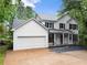 Charming two-story home with white siding, black shutters, red front door, and a well-manicured lawn at 1620 Bluewater Ct, Cumming, GA 30041
